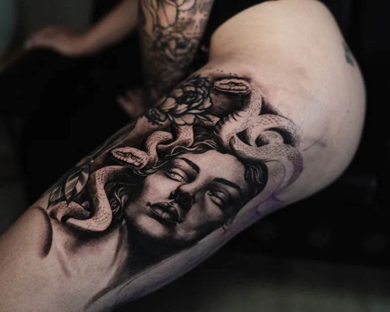 Realistisches Medusa-Tattoo mit Schlangen und Schattierungen am Oberarm